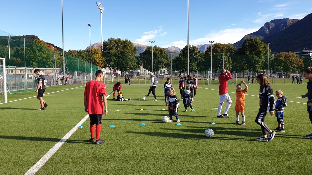 I Camaleonti, giocatori con disabilità, ritratti mentre aiutano i piccolini a a fare esercizi calcistici. Alcuni bambini hanno poi provato a giocare a calcio in squadre tipiche. 